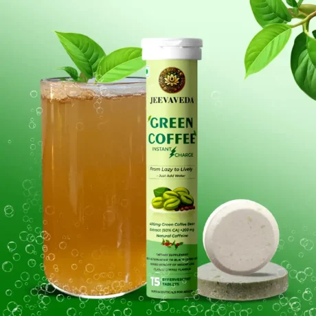 Jeevaveda Green Coffee Boost product display, featuring a tube of effervescent tablets, a single tablet, and a glass of the prepared beverage, accessorized with fresh green foliage.